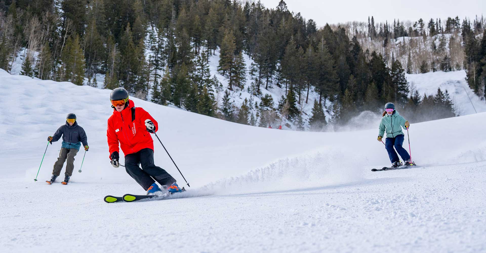 Ski instructor leads a group down a blue run at Aspen Mountain