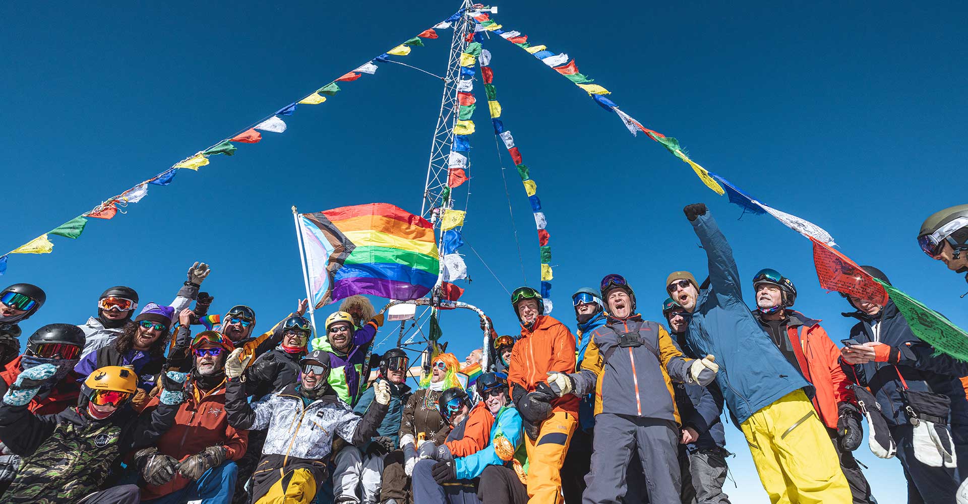 A group of skiers and hikers celebrate Aspen Gay Ski Week atop Highland Peak