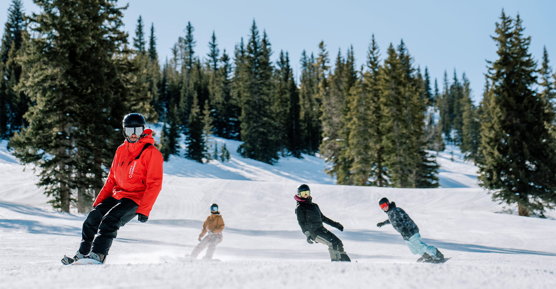 Snowboard Pro leads his group down groomer at Aspen Snowmass