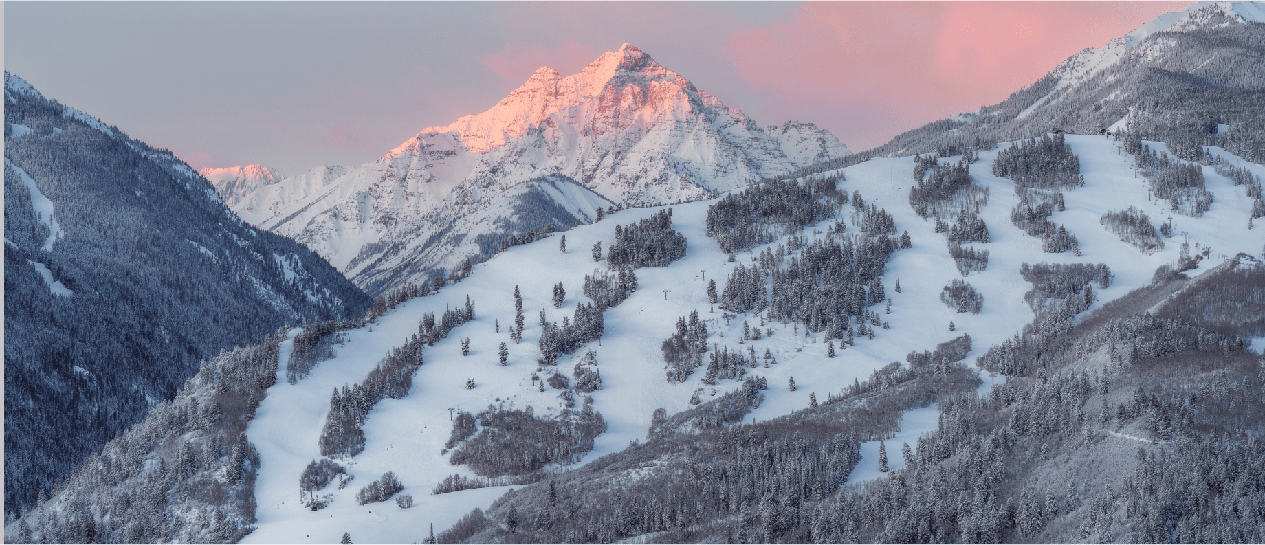 Dawn over buttermilk ski resort, pink skies highlight the maroon bells in distance