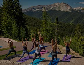 A group doing yoga on Aspen Mountain, Colorado